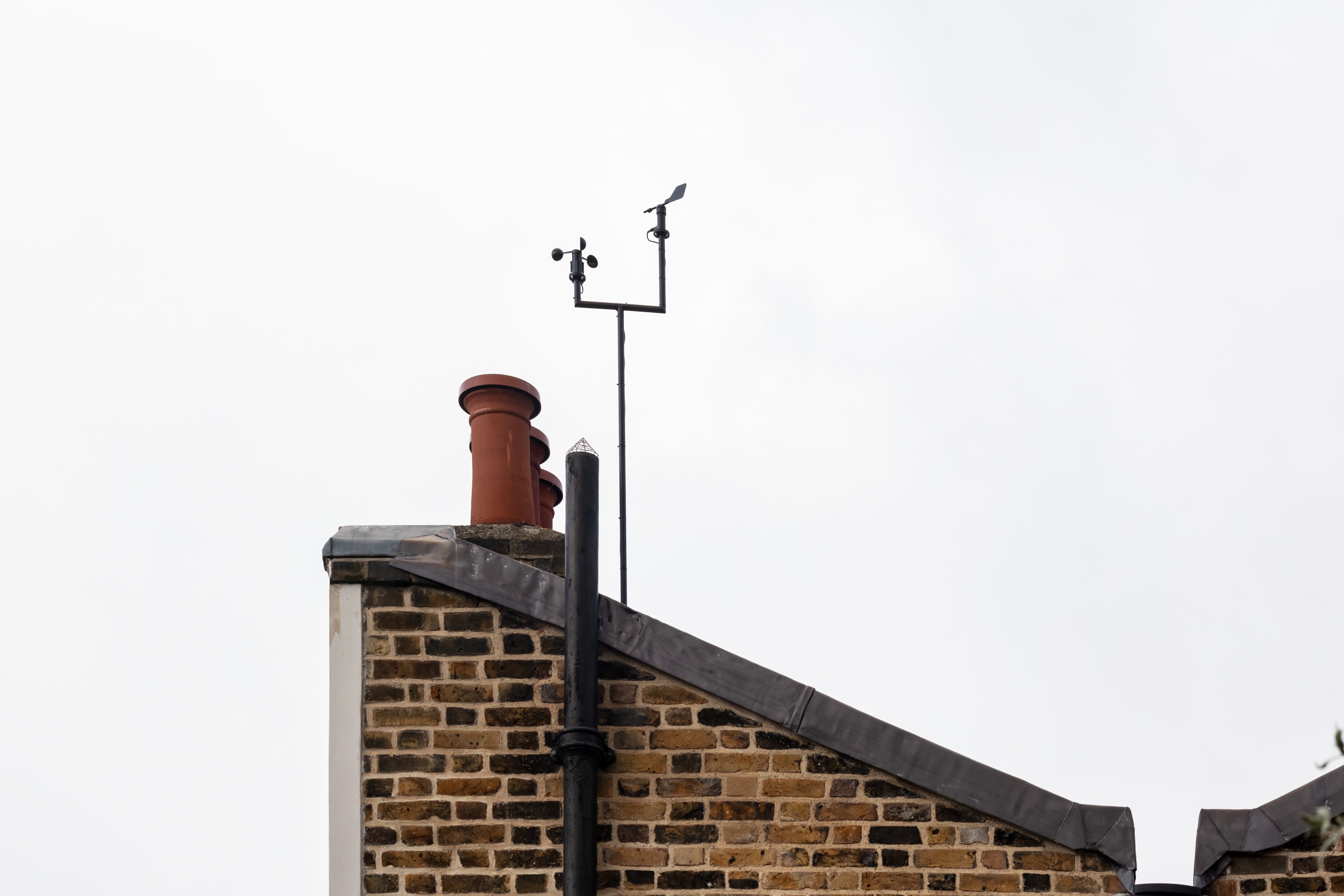 A chimney stand on top of a brick house against a white background